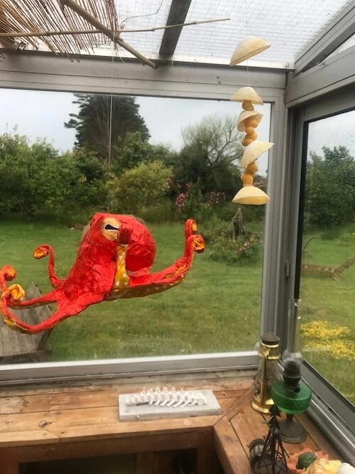 Petite pieuvre orange suspendue dans une véranda